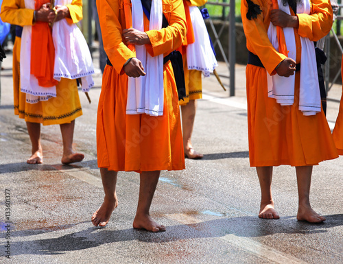 Sikh men walk with swords in hand through the streets of the cit