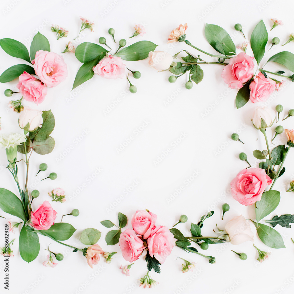 Round frame made of pink and beige roses, green leaves, branches on white background. Flat lay, top view. Valentine's background