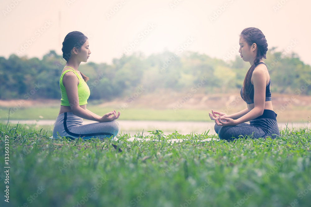 Beautiful Asian women doing yoga in park