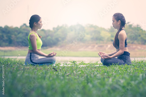 Fototapeta Naklejka Na Ścianę i Meble -  Beautiful Asian women doing yoga in park