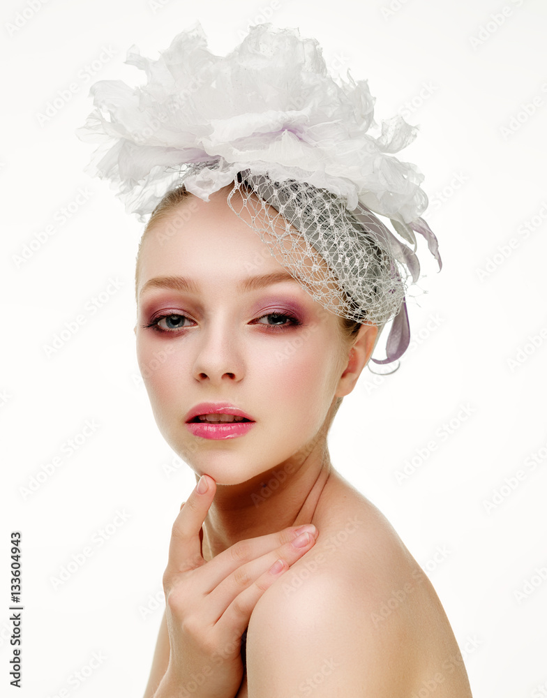 Beautiful girl in a wedding hat over white background