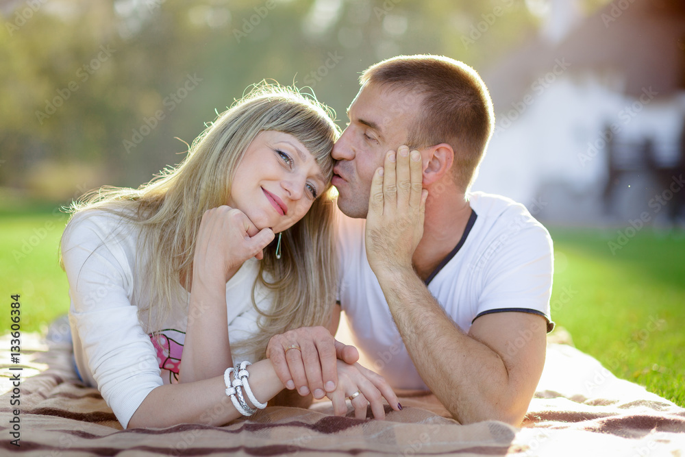 Fototapeta premium husband with the pregnant wife lie on a grass