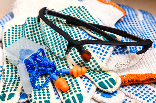 work gloves, protective glasses and ear plugs close up,