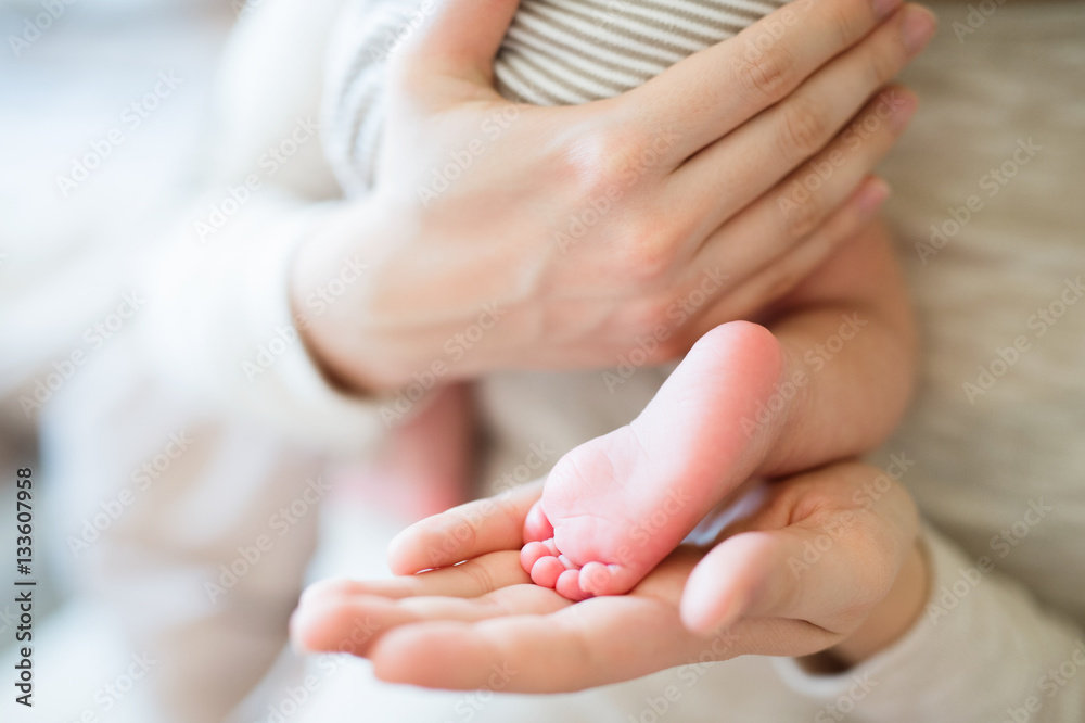 Unrecognizable mother with newborn baby son, legs and hands Unrecognizable mother with newborn baby son, legs and hands