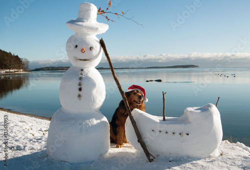 Fototapeta Naklejka Na Ścianę i Meble -  Schneemann mit fröhlichen Hund an der Ostsee-Insel Rügen im Winter