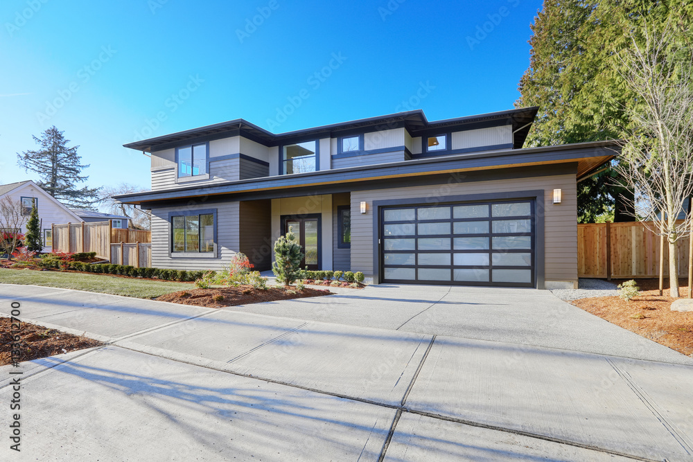 New construction home with low slope roof and brown siding. New construction home with low slope roof and brown siding.