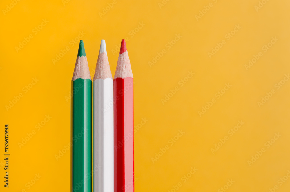 Three colored pencils on yellow background Three colored pencils on yellow background