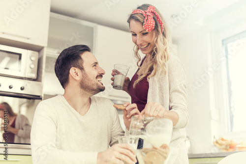 Cute couple having breakfast at home in the kitchen