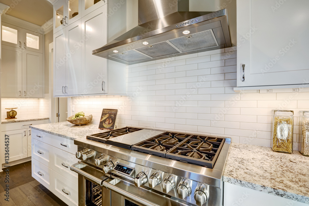 Beautiful kitchen features a nook filled with steel stove Beautiful kitchen features a nook filled with steel stove