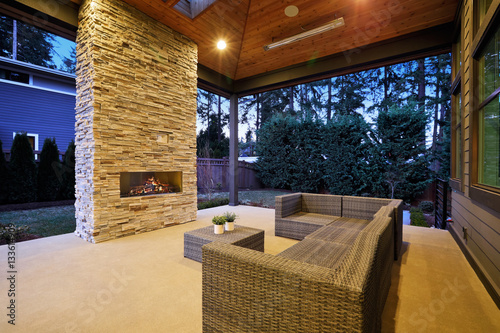 Chic patio design with vaulted ceiling and stone fireplace © Iriana Shiyan