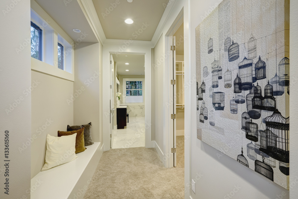 White hallway space with built-in seat topped with pillows