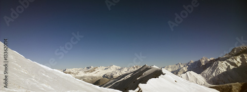 Aerial Views of an Alpine Valley and High Mountains covered in Fresh Snow