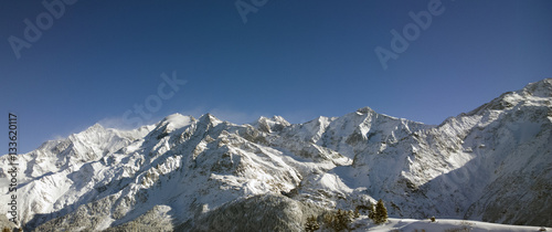 Aerial Views of an Alpine Valley and High Mountains covered in Fresh Snow