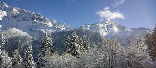Aerial Views of an Alpine Valley and High Mountains covered in Fresh Snow