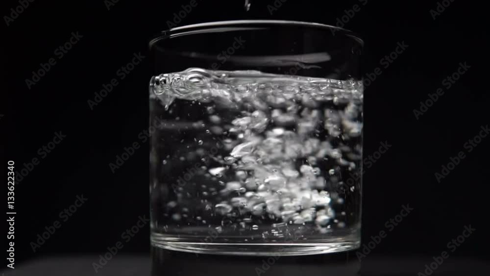 Effervescent Antacid Tablet in Glass of Water on Black Effervescent Antacid Tablet in Glass of Water on Black