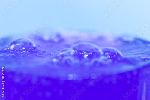 in a glass of blue cocktail with bubbles close-up
