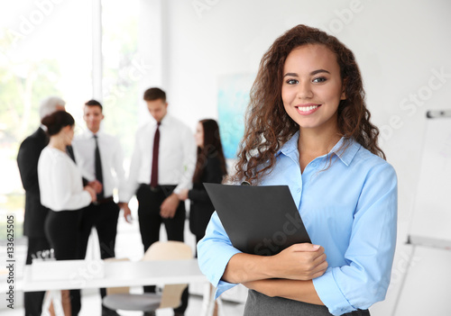 Business training concept. Beautiful woman with clipboard standing in office