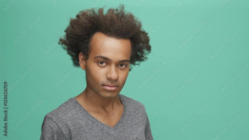 Smiling afro american man pointing finger at camera isolated on a green background Smiling afro american man pointing finger at camera isolated on a green background