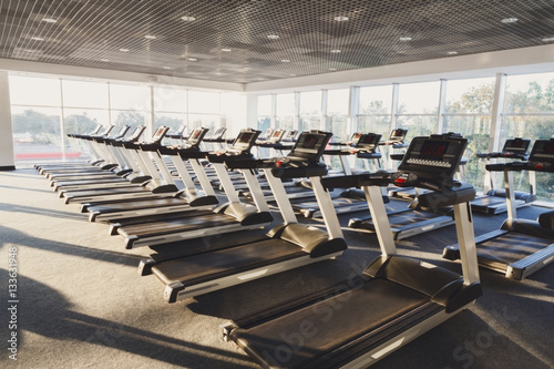 Modern gym interior with equipment, treadmills for fitness cardio training