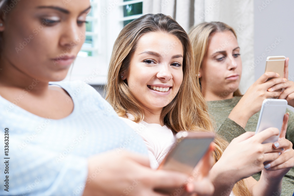 Group Of Teenage Girls Using Mobile Phones At Home Group Of Teenage Girls Using Mobile Phones At Home