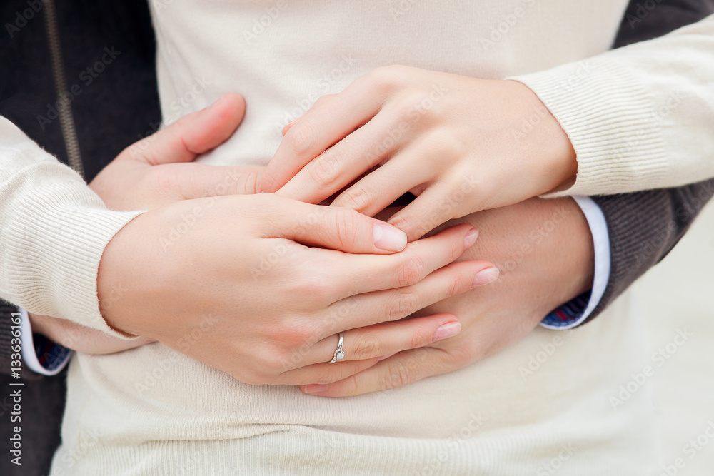 the young pair holds a hand in a hand with a wedding ring close the young pair holds a hand in a hand with a wedding ring close