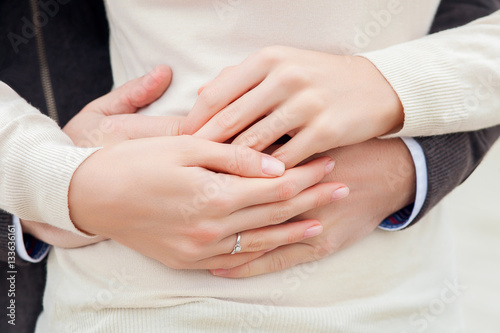 the young pair holds a hand in a hand with a wedding ring close