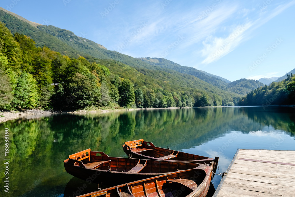 Boats tied to wooden pontoon on lake in Montenegro