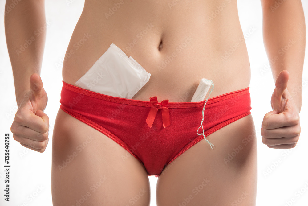Girl in red shorts holding a hygienic tampons and pads during me Girl in red shorts holding a hygienic tampons and pads during me