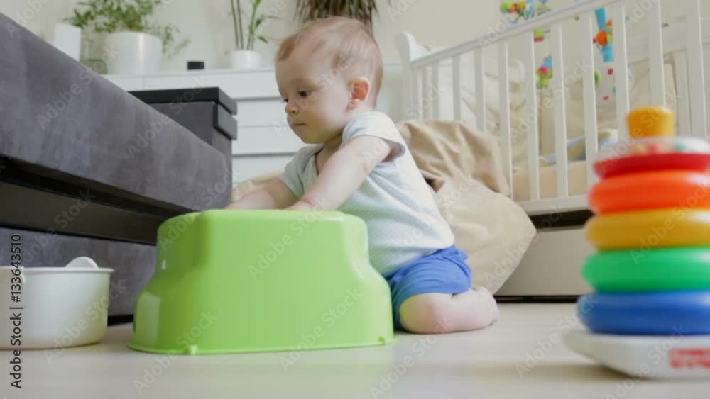 Dolly shot of cute baby boy pretending to play on drums on floor at living room Dolly shot of cute baby boy pretending to play on drums on floor at living room