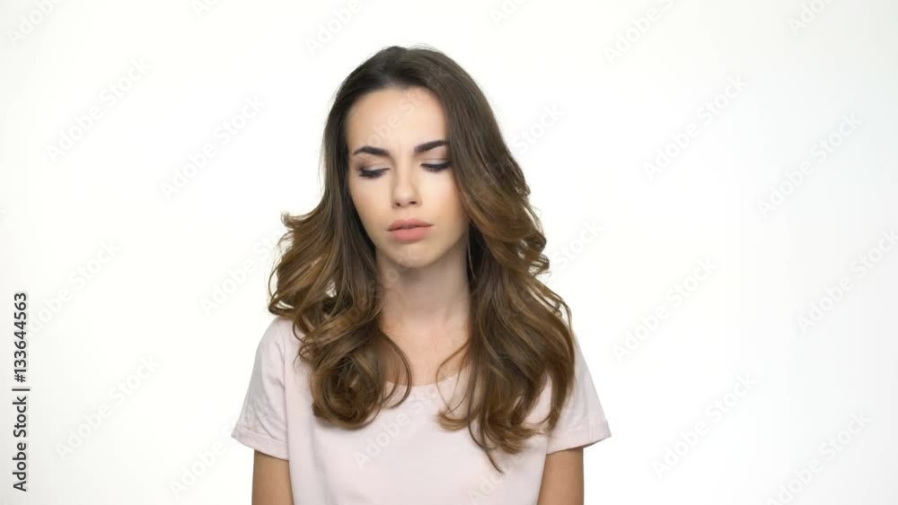 Sad young teenage girl looking both ways while standing isolated on white Sad young teenage girl looking both ways while standing isolated on white