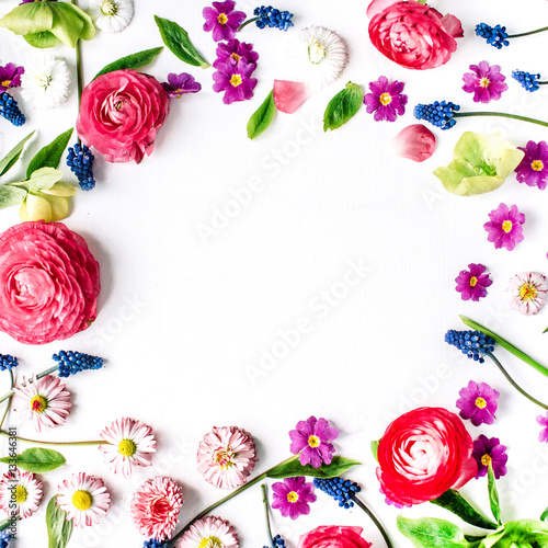 Frame of roses, muscari, chamomile, ranunculus, branches, leaves, petals and buds on white background. Flat lay, top view © Floral Deco