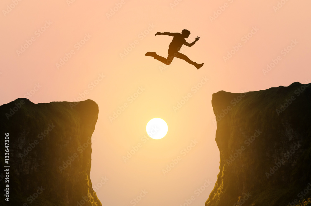 man jumping over the cliff, silhouette