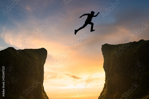man jumping over the cliff, silhouette
