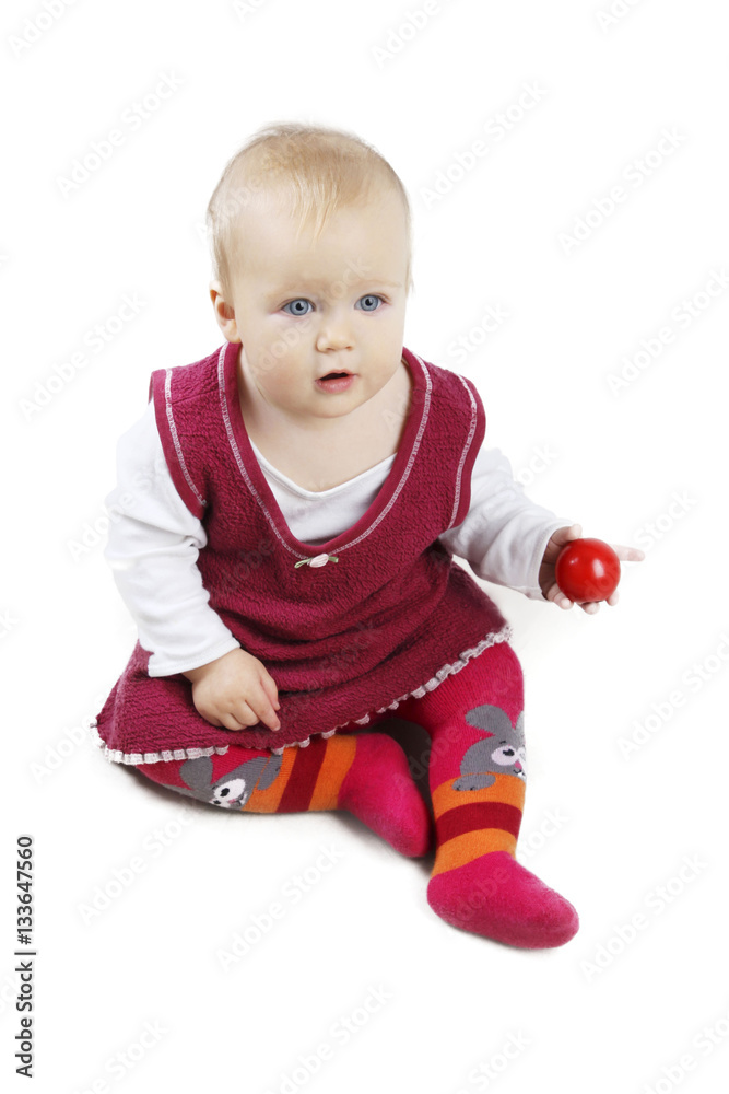 Adorable little baby girl in red dress sitting and playing with red ball - isolated over white background. Adorable little baby girl in red dress sitting and playing with red ball - isolated over white background.