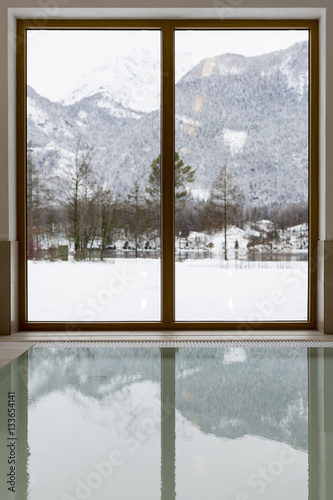 Swimming Pool with Snow Covered Mountain Lake View. Winter Idyll Window.