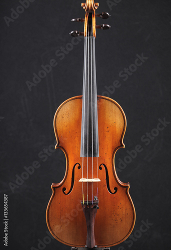 Old wooden violin on black background