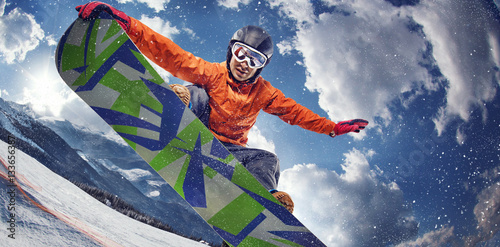 Sport background. Winter sport. Snowboarder jumping through air with deep blue sky in background.