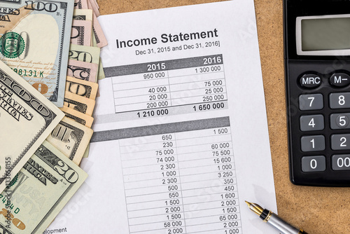 Save money concept - doc income statement with pen, calculator and money.