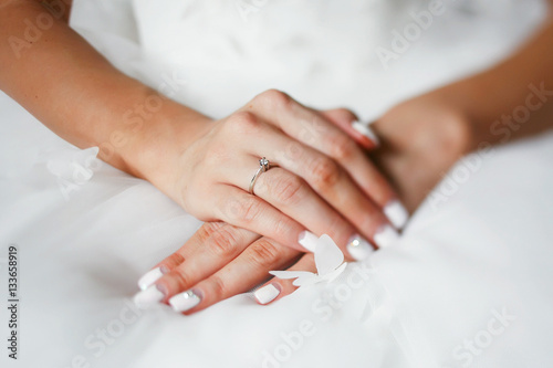 Bride crosses her hands with white nails