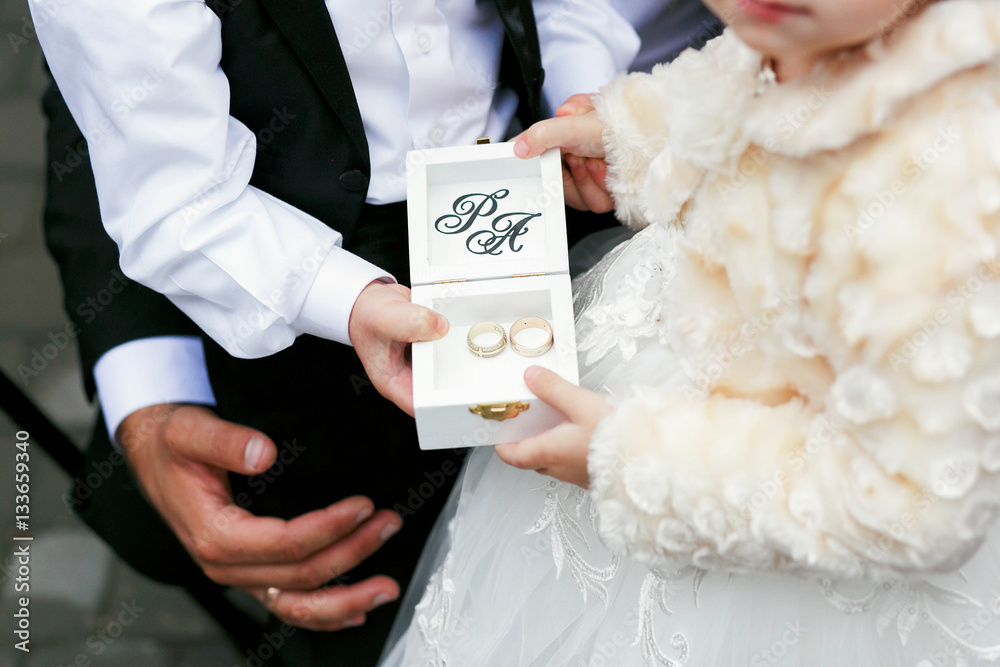 Little children hold elegant box with wedding rings
