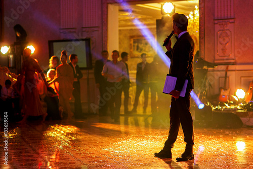 Cuadro en lienzo Man with microphone stands in the middle of sparkling dancefloor