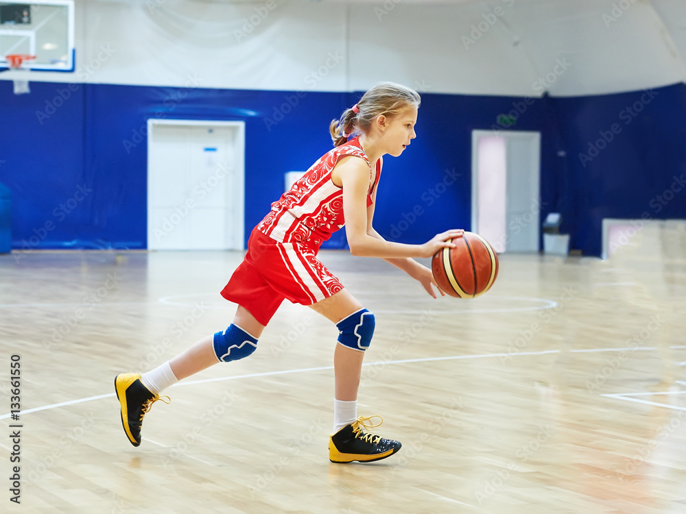 Girl athlete in uniform playing basketball