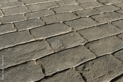 Gray stamped concrete pavement outdoor, mimics cobblestones pattern, decorative appearance colors and textures of paving cobble stone, perspective flooring exterior