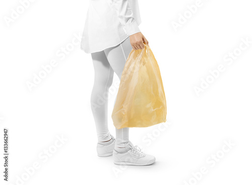 Blank yellow plastic bag mockup holding hand. Woman hold dark carrier sac mock up. Grey bagful branding template. Shopping carry package in persons arm. Promotional packet for logo branding.