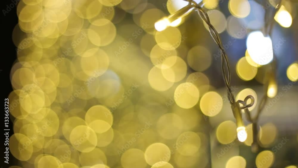 Defocused night street lights blurred colorful bokeh background. Holiday colorful lanterns and light bulbs garlands.