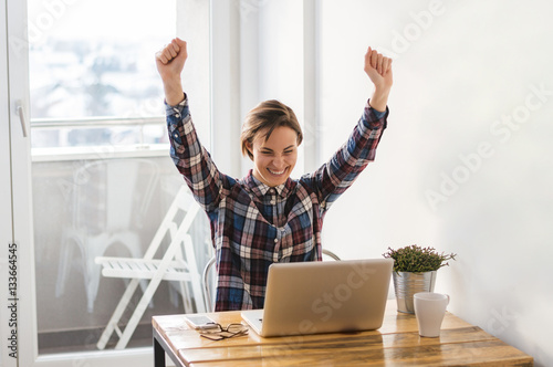 Euphoric and surprised winner winning online watching a laptop a