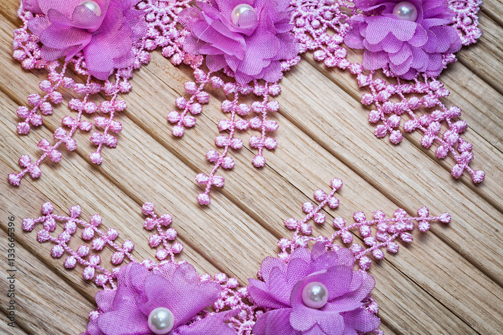 Floral lace on a wooden background with copy space. Suitable as a wedding invitation. Floral lace on a wooden background with copy space. Suitable as a wedding invitation.