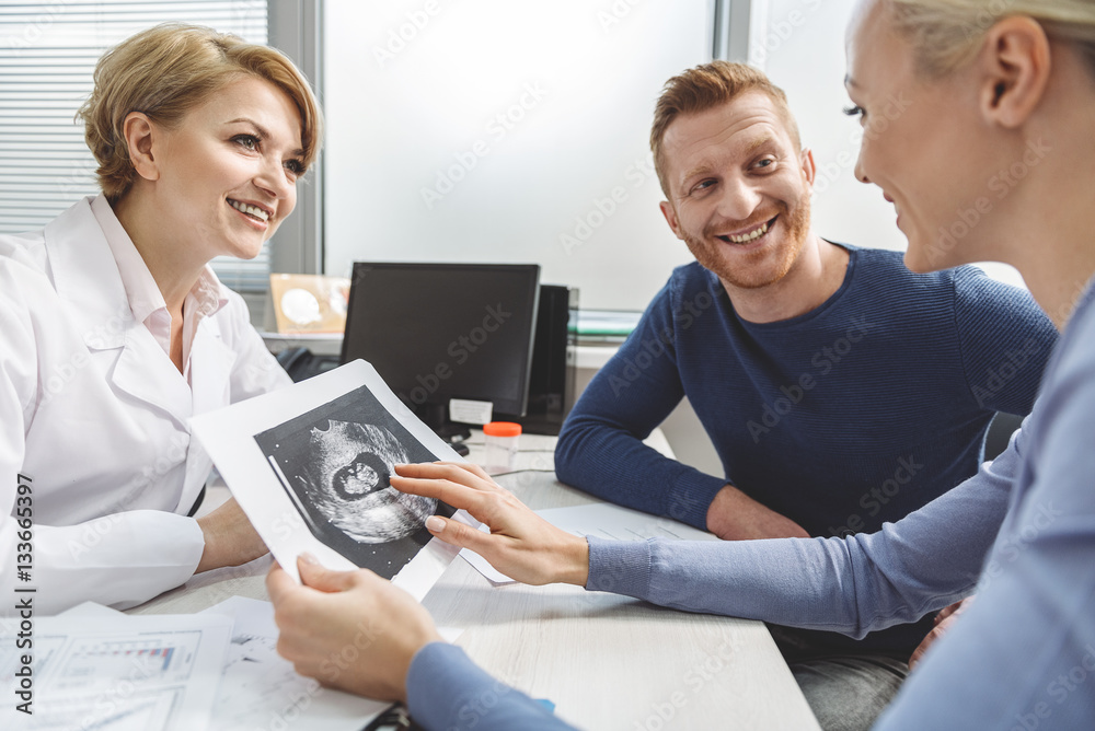 Happy couple visiting female doctor