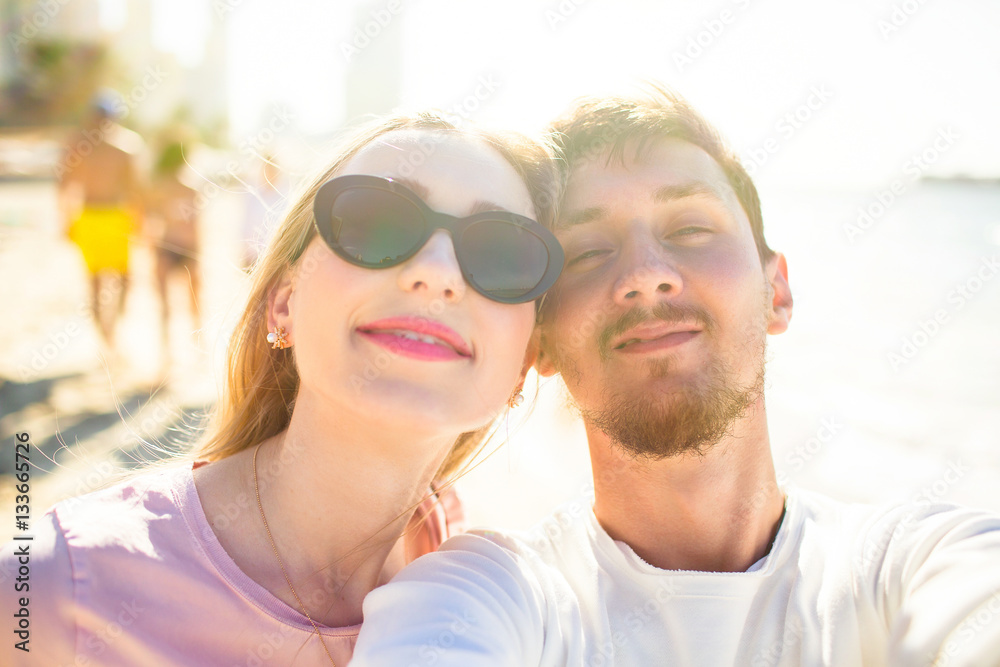 Happy lady in black sunglasses and bearded man pose face to face