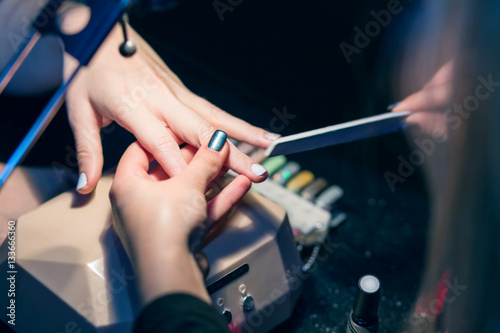 Manicure set in a beauty salon. Beautiful female hands